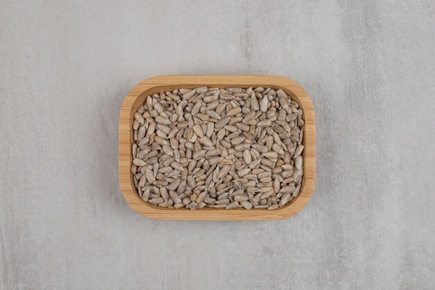 Pila de semillas de girasol en placa de madera.