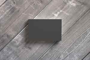 Foto gratuita pila de tarjetas de papel negro en escritorios de madera. plantilla para exhibir su presentación.