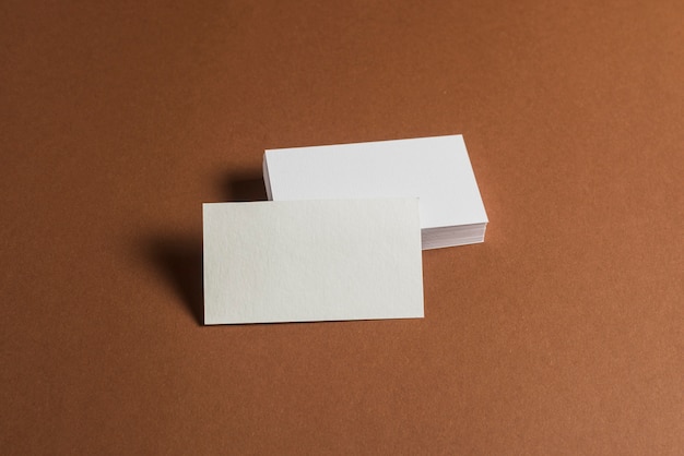 Pila de tarjetas de visita en blanco sobre fondo marrón