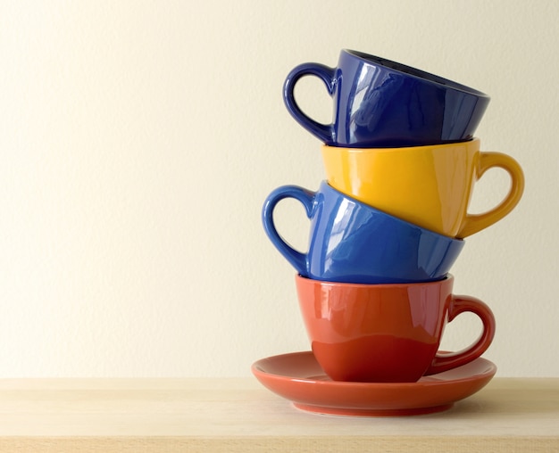 Pila de tazas de café de colores sobre la mesa