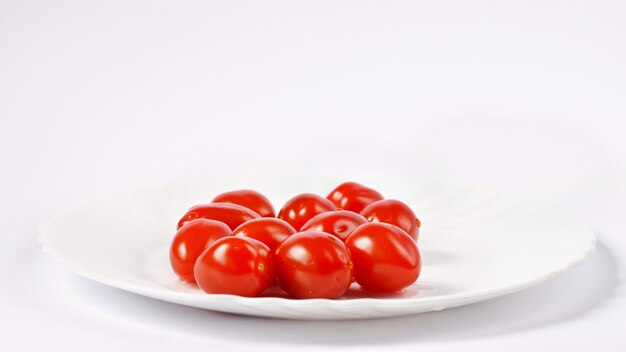 Pila de tomates cherry aislada sobre fondo blanco