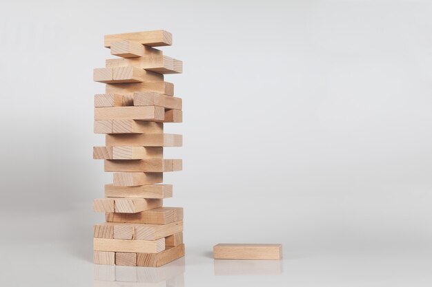 Pila de una torre de bloques de madera aislada en una pared blanca