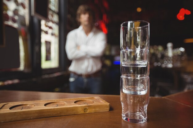 Pila vacía de vaso de cerveza y bandeja en barra de bar