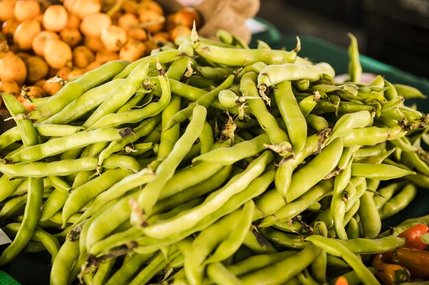 Pila de vegetales de guisantes verdes en puesto de mercado