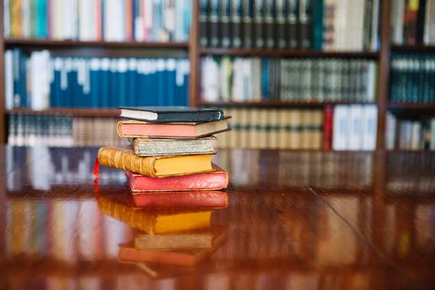 Pila de viejos libros en la mesa de la biblioteca