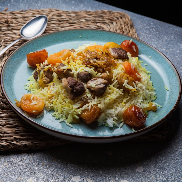 pilaf con frutos secos y secos y castaña y cuchara en plato redondo