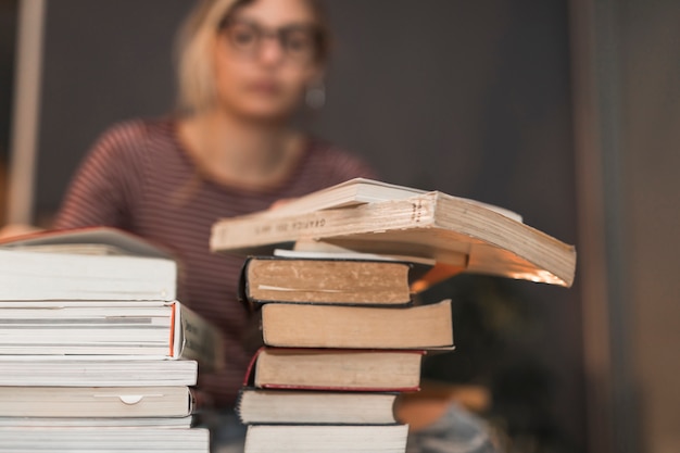 Pilas de libros cerca de mujer