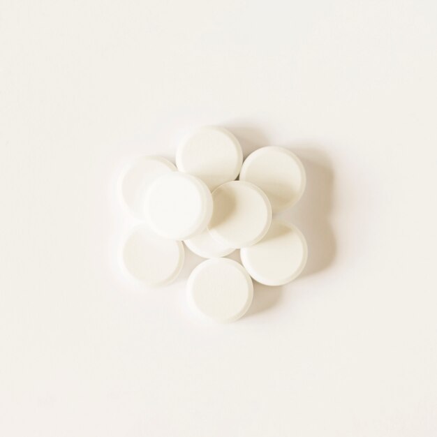 Píldoras circulares blancas sobre fondo blanco
