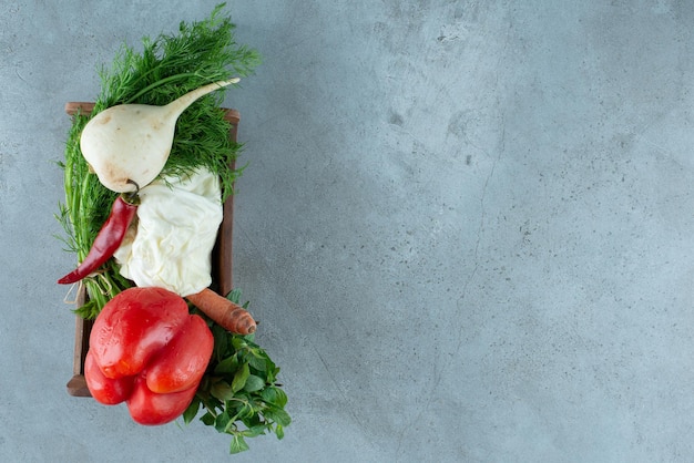 Foto gratuita pimienta, rábano blanco y verduras en caja de madera.