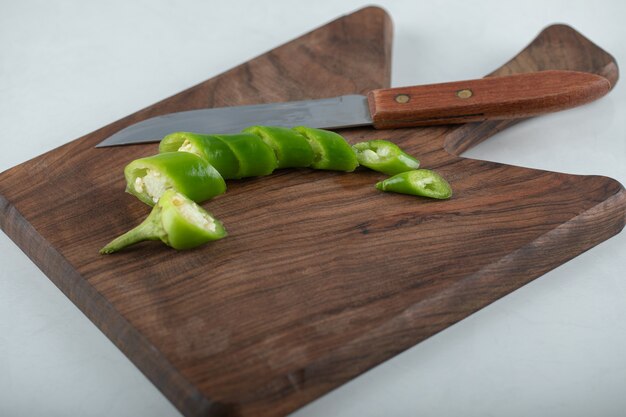 Pimiento picante en rodajas sobre una tabla de cortar de madera.