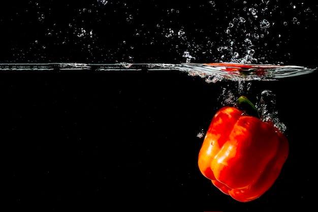 Pimiento rojo flotando bajo el agua clara