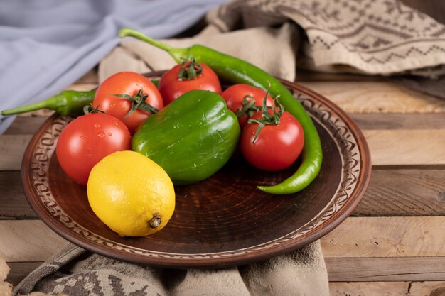 Pimiento verde con tomate y limón en una fuente marrón