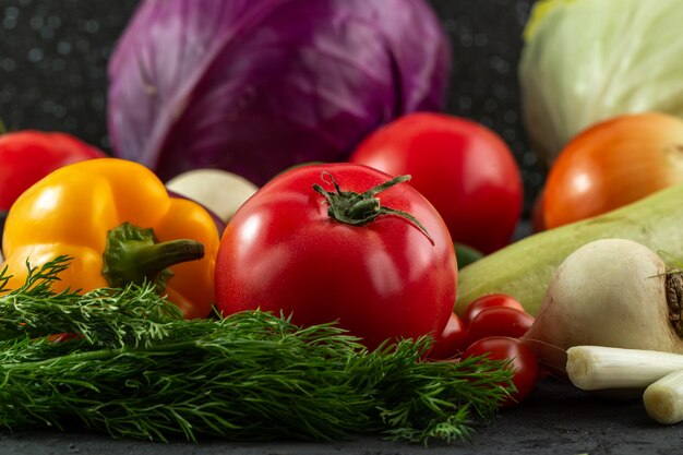 Pimiento verde vitamina rica ensalada de verduras incluyendo tomate y repollo morado sobre fondo oscuro