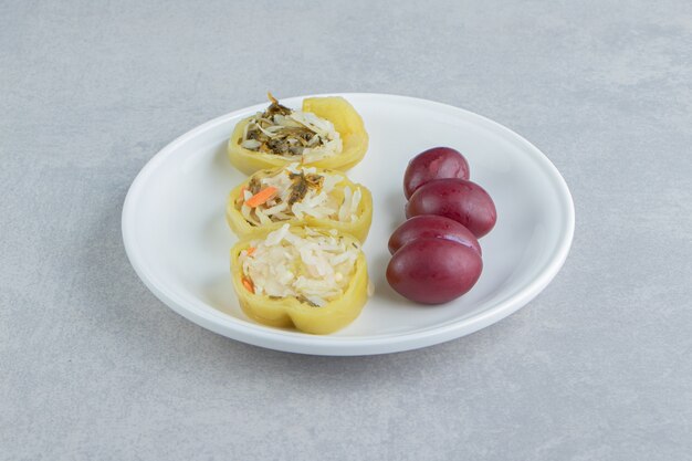 Pimientos y ciruelas rellenas en un plato blanco.