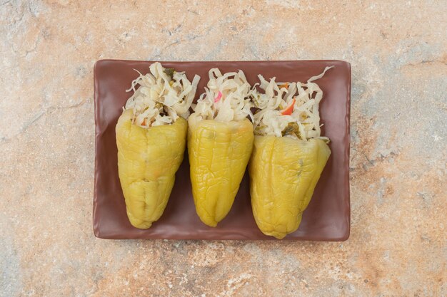 Pimientos en escabeche rellenos con chucrut en placa marrón