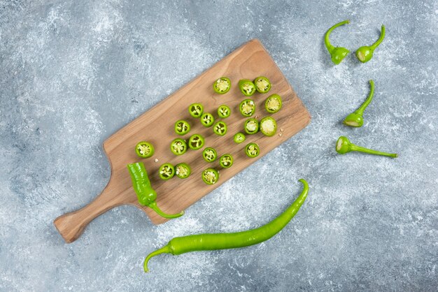 Pimientos jalapeños en rodajas sobre tabla de madera.