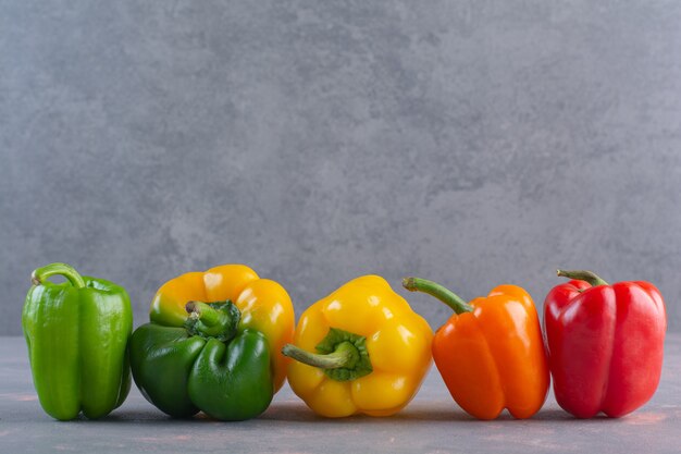 Pimientos orgánicos coloridos frescos colocados sobre la superficie de la piedra