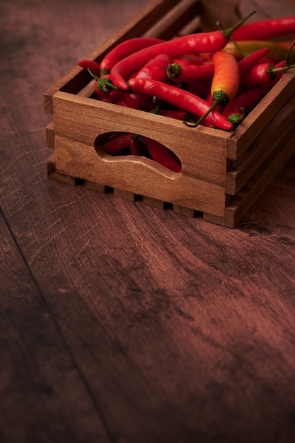 Pimientos rojos en una caja puesta sobre una superficie de madera