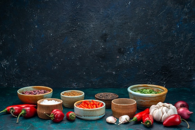 Foto gratuita pimientos rojos fríos con cebollas ajos verdes en la oscuridad