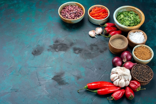 Foto gratuita pimientos rojos fríos con cebollas verdes ajos verdes en la oscuridad