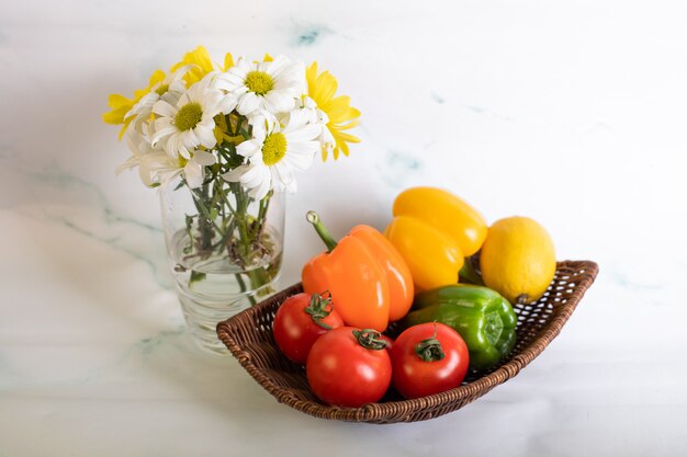 Pimientos y tomates en la bandeja sobre el mármol