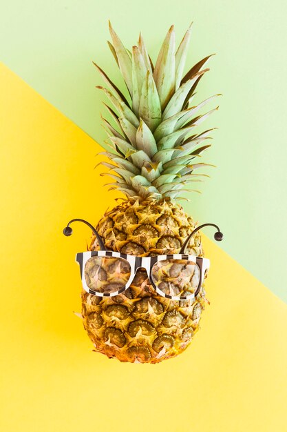 Piña en gafas de sol sobre fondo multicolor