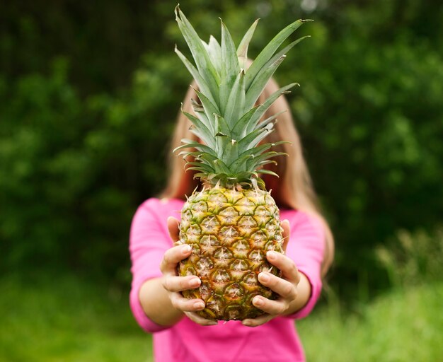 Piña en manos de una mujer hermosa