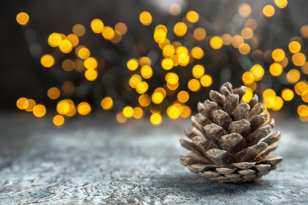 Piña de vista frontal en luces de Navidad de superficie aislada oscura