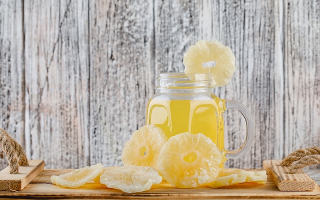 Piñas secas con jugo en una bandeja sobre superficie de madera