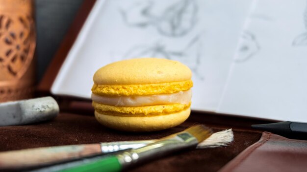 Pinceles de composición de macaron amarillo y dibujo cerca de él