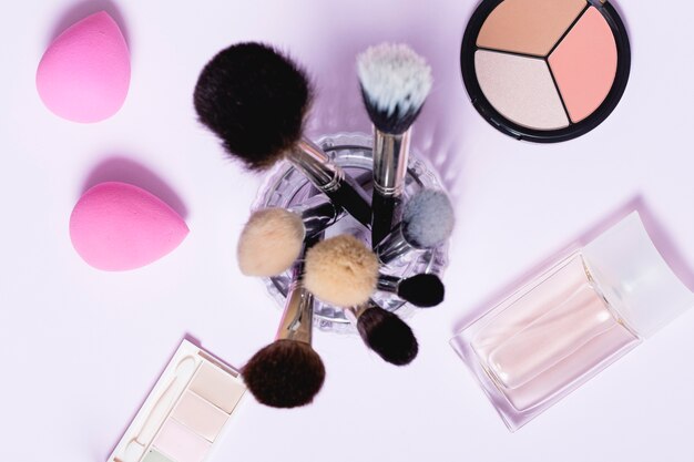 Pinceles de maquillaje en medio de los cosméticos