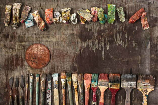 Pinceles y tubos de pinturas al óleo sobre madera.