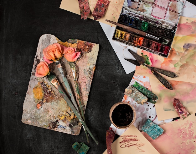 Pinceles y tubos de pinturas al óleo sobre mesa de madera