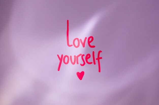 Pink Love yourself inscripción en la mesa