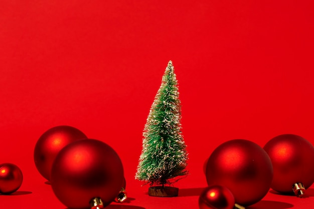 Foto gratuita pino con bola roja de navidad en pared roja