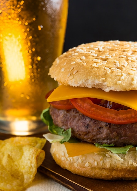 Pinta de cerveza con hamburguesa con queso y patatas fritas