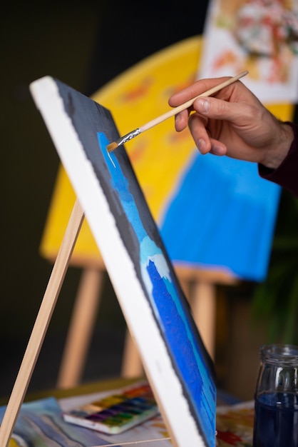 Pintor masculino usando acuarela en su arte en el estudio.