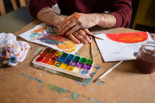 Foto gratuita pintor masculino usando acuarela en su arte en el estudio.