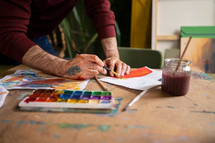 Foto gratuito pintor masculino usando acuarela en su arte en el estudio.