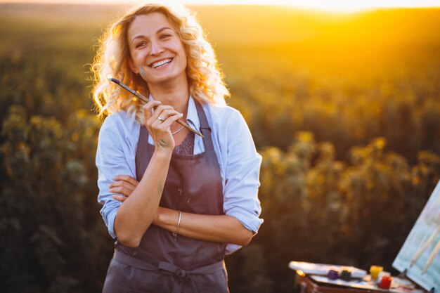 Pintor de mujer en un campo