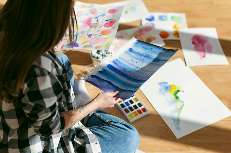 Foto gratuito pintora contemporánea creativa poniendo sus dibujos en el suelo