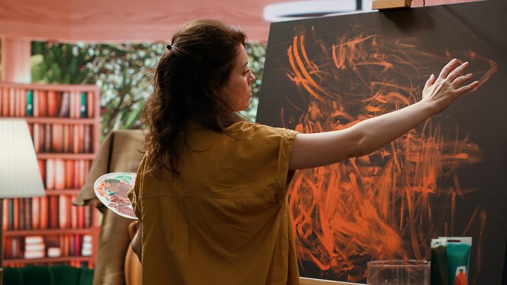 Foto gratuito la pintora trabaja con la técnica de pintura de dedos en su última obra de arte