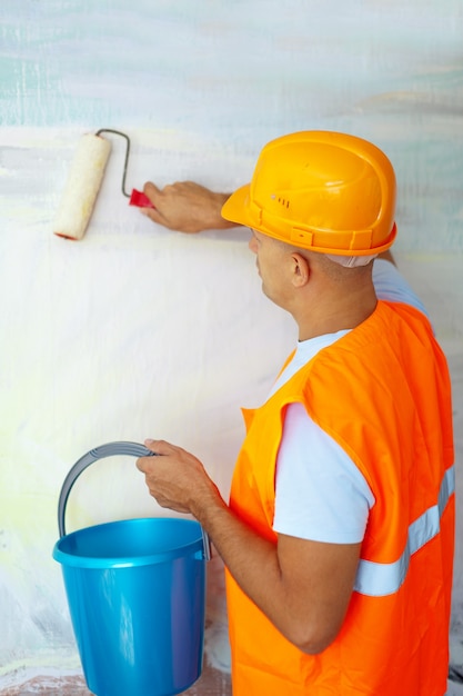 Pintores de casas con rodillo de pintura en la casa