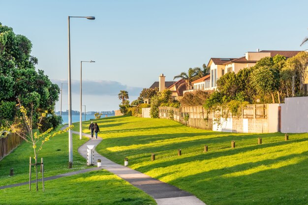 Pintoresco paisaje con hermosas casas a la orilla del mar y un césped bien cuidado con un camino