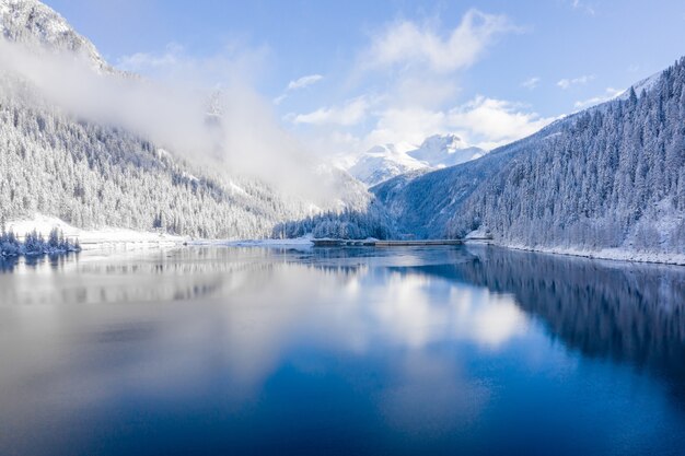 Pintoresco paisaje de montañas cubiertas de nieve y un lago cristalino en Suiza