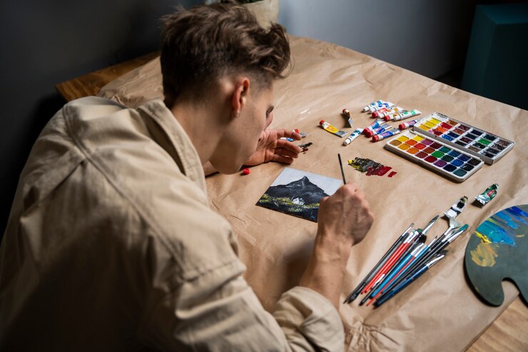 Foto gratuito pintura de artista con acuarelas de alto ángulo