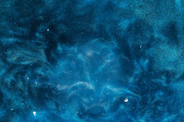Pintura azul que fluye en aguas oscuras