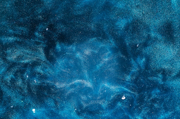 Pintura azul que fluye en aguas oscuras