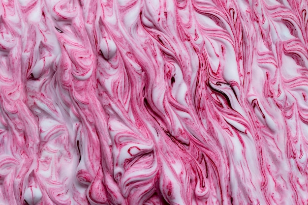 Pintura de color rosa mezclada en fondo de espuma blanca.