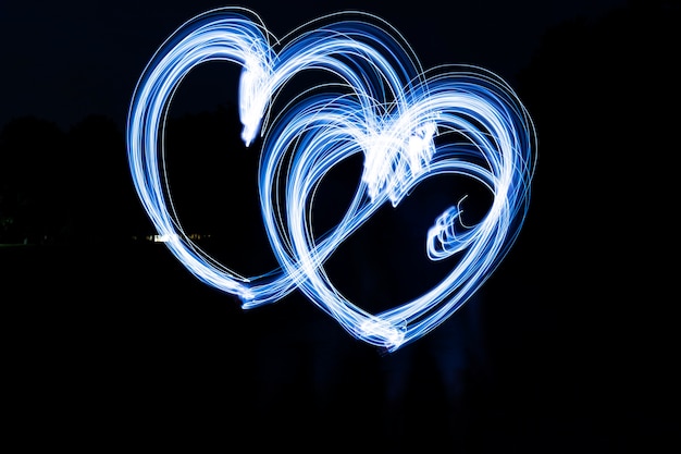 Pintura de luz en forma de corazón azul con fondo oscuro